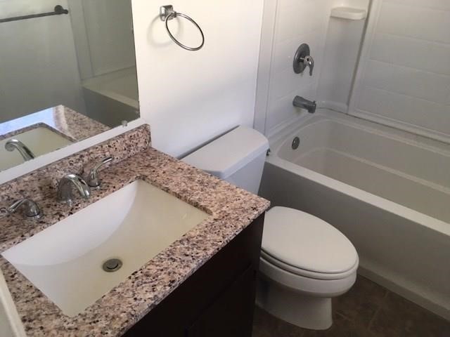 5017 Meandering Lane, Unit A Corpus Christi, TX 78413 - Photo 10 of 13 a bathroom with a granite countertop sink toilet and shower