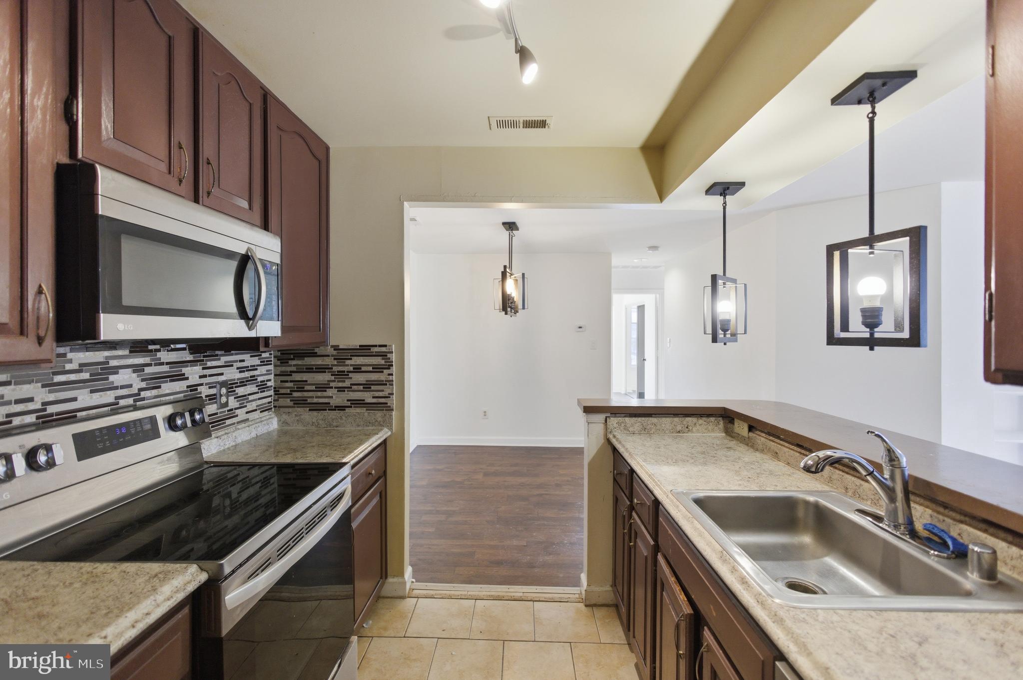 13609 Sir Thomas Way, Unit 1C24 Silver Spring, MD 20904 - Photo 11 of 16 a kitchen that has a sink and a stove