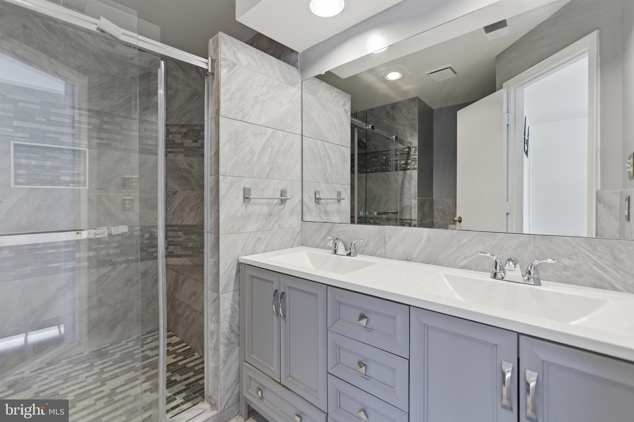 13609 Sir Thomas Way, Unit 1C24 Silver Spring, MD 20904 - Photo 14 of 16 a bathroom with a sink double vanity and shower