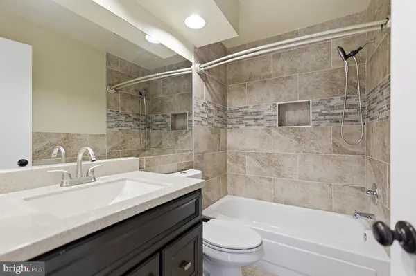a bathroom with a sink shower bathtub and toilet