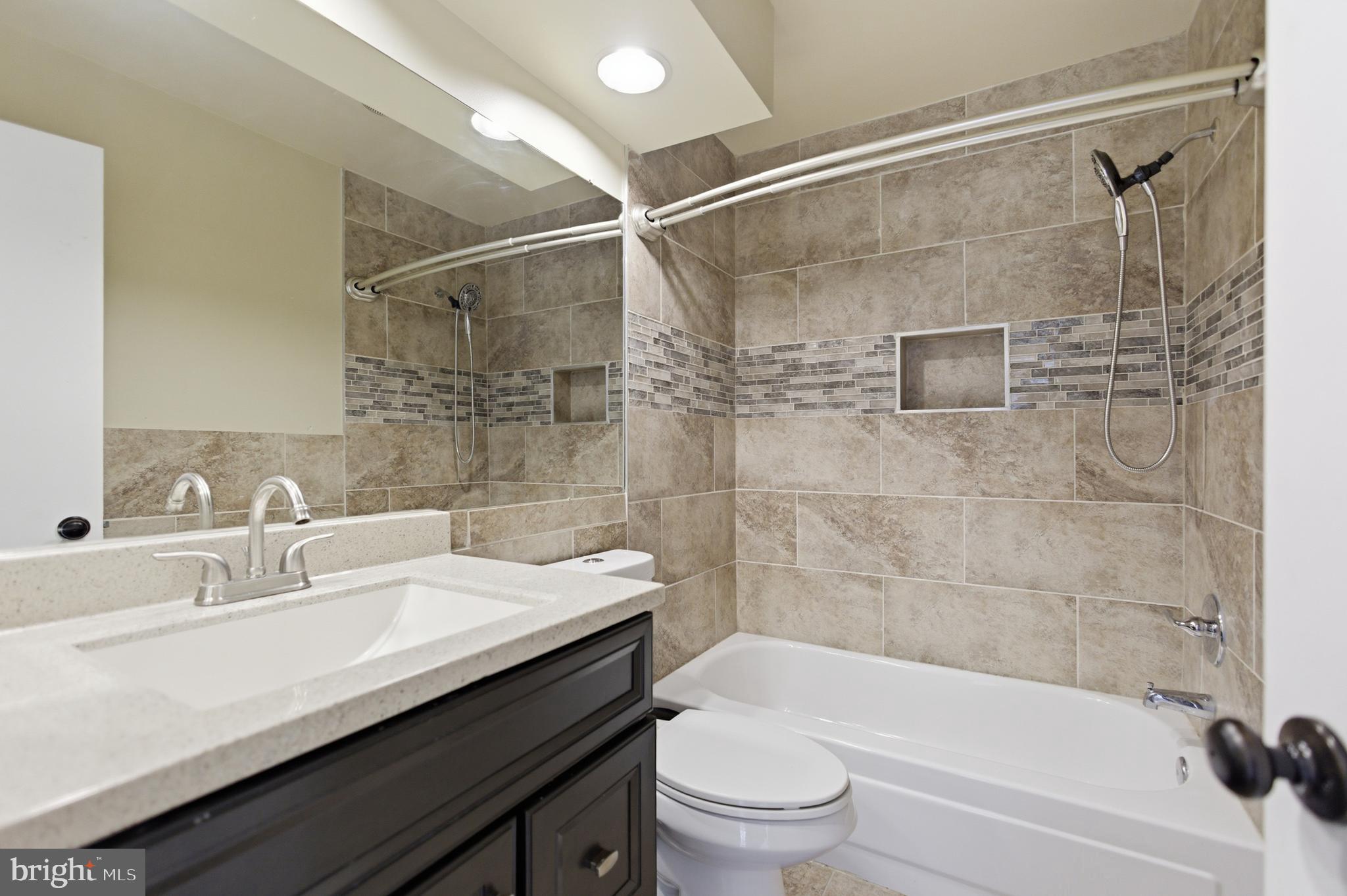 13609 Sir Thomas Way, Unit 1C24 Silver Spring, MD 20904 - Photo 15 of 16 a bathroom with a sink shower bathtub and toilet