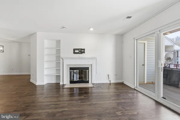 a view of empty room with wooden floor and fireplace