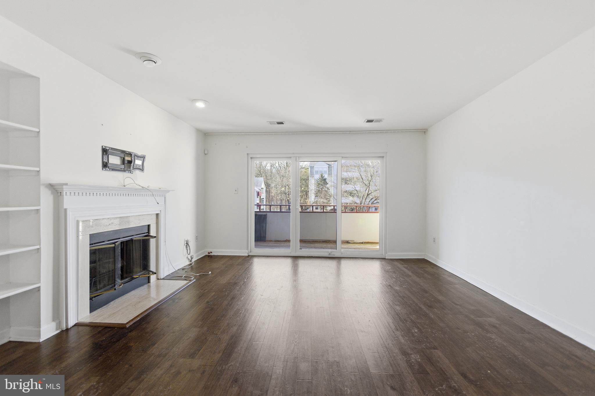 13609 Sir Thomas Way, Unit 1C24 Silver Spring, MD 20904 - Photo 3 of 16 a view of an empty room with wooden floor and a window