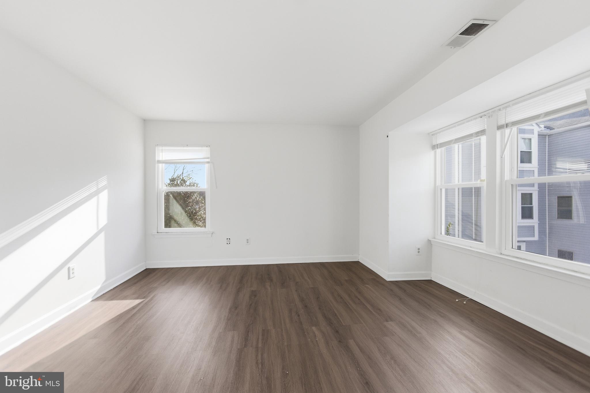 13609 Sir Thomas Way, Unit 1C24 Silver Spring, MD 20904 - Photo 6 of 16 an empty room with wooden floor and windows