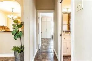 a view of a hallway with wooden floor and a potted plant