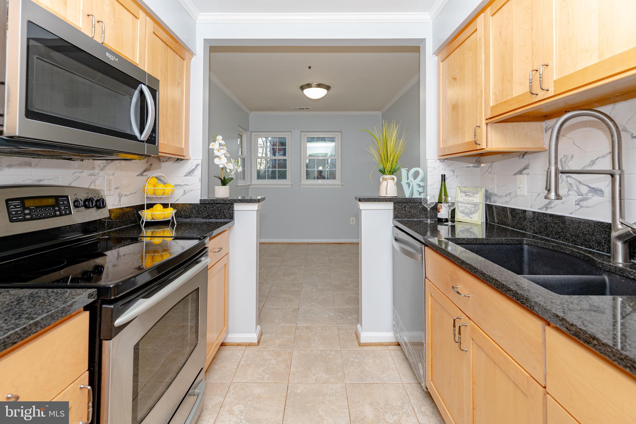 8347 Montgomery Run Road, Unit B Ellicott City, MD 21043 - Photo 9 of 39 a kitchen with stainless steel appliances granite countertop a sink and stove top oven