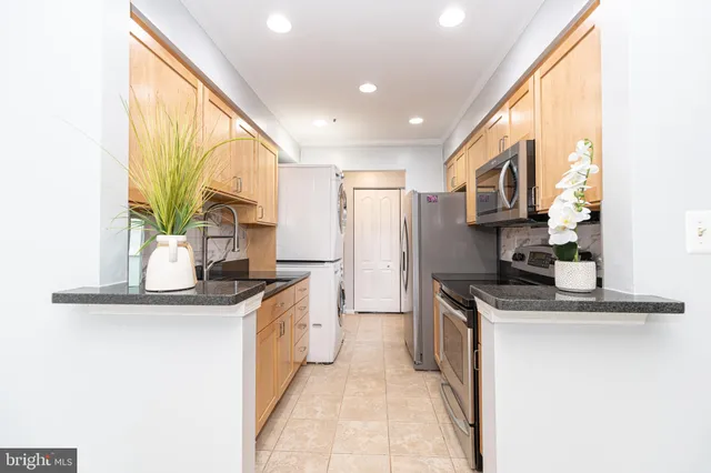 a kitchen with stainless steel appliances granite countertop a sink a stove and a refrigerator