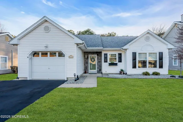 a front view of a house with a garden and yard