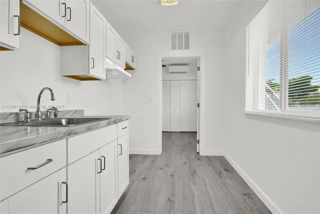 a kitchen with granite countertop white cabinets and sink