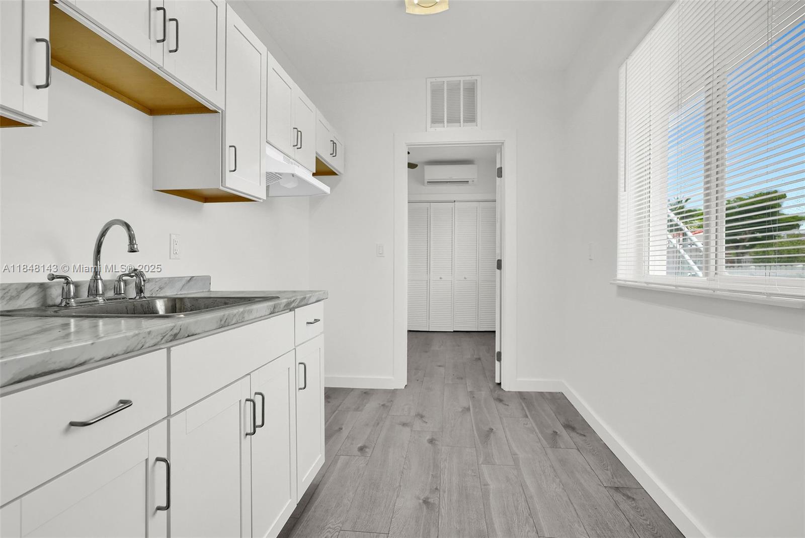 600 Northwest 25th Court Miami, FL 33125 - Photo 12 of 16 a kitchen with granite countertop white cabinets and sink