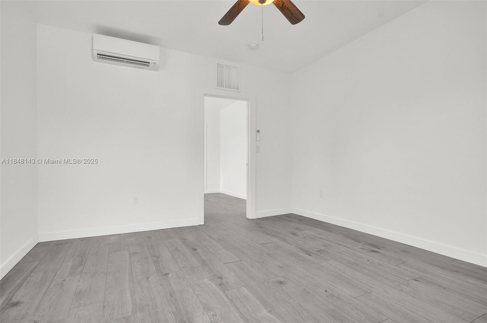 600 Northwest 25th Court Miami, FL 33125 - Photo 5 of 16 an empty room with wooden floor cabinets and fan