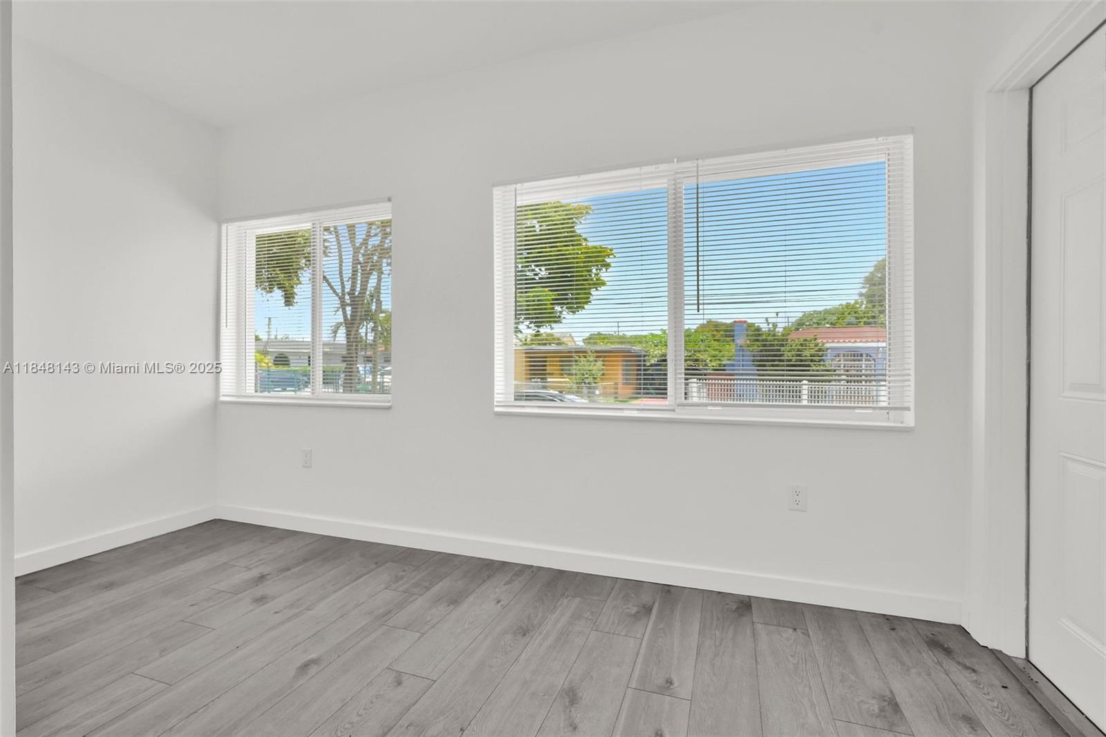 600 Northwest 25th Court Miami, FL 33125 - Photo 6 of 16 a view of an empty room with wooden floor and a window