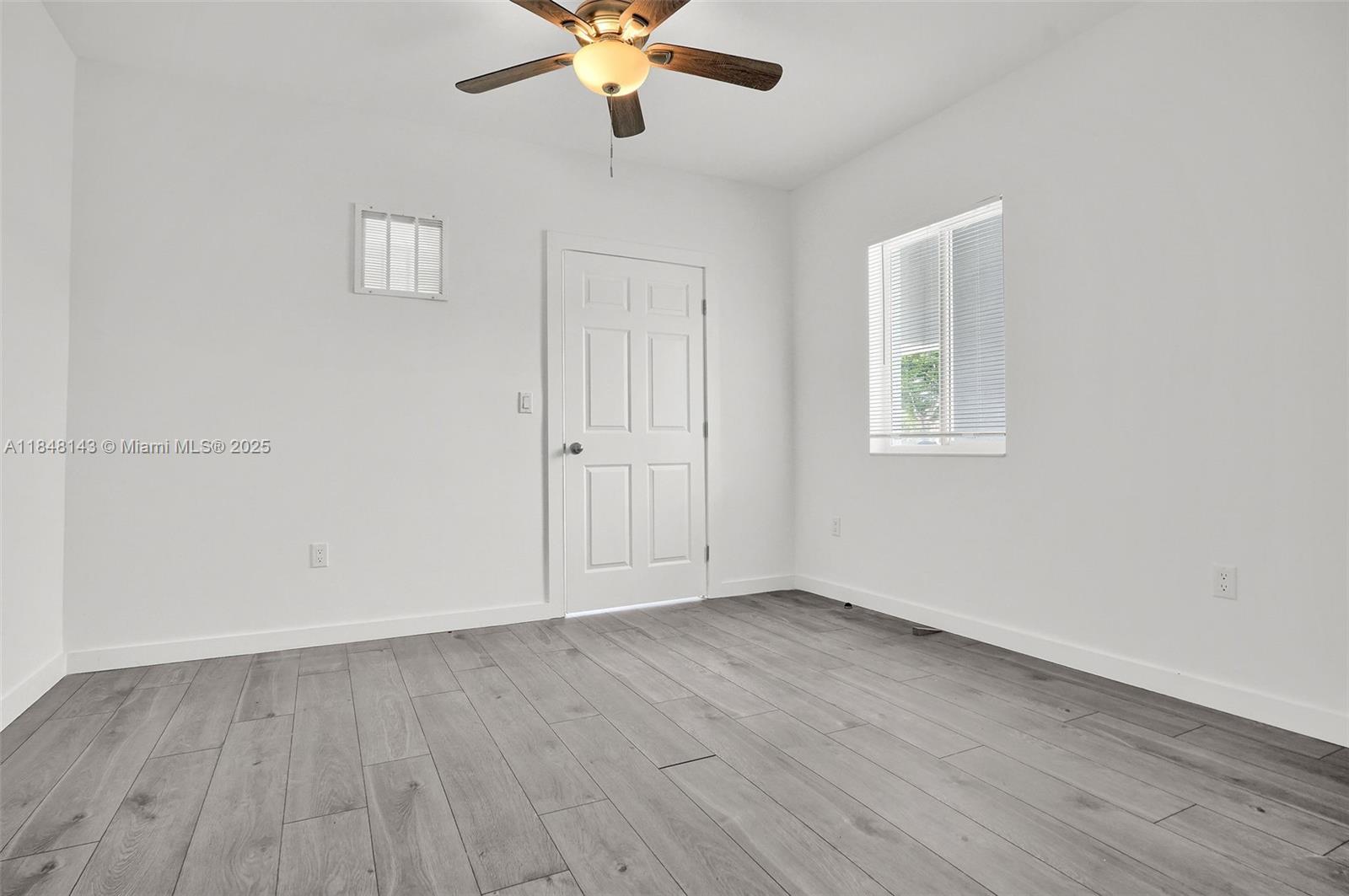 600 Northwest 25th Court Miami, FL 33125 - Photo 8 of 16 an empty room with wooden floor fan and windows