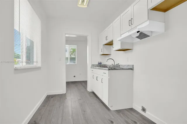 a kitchen with granite countertop white cabinets and white appliances