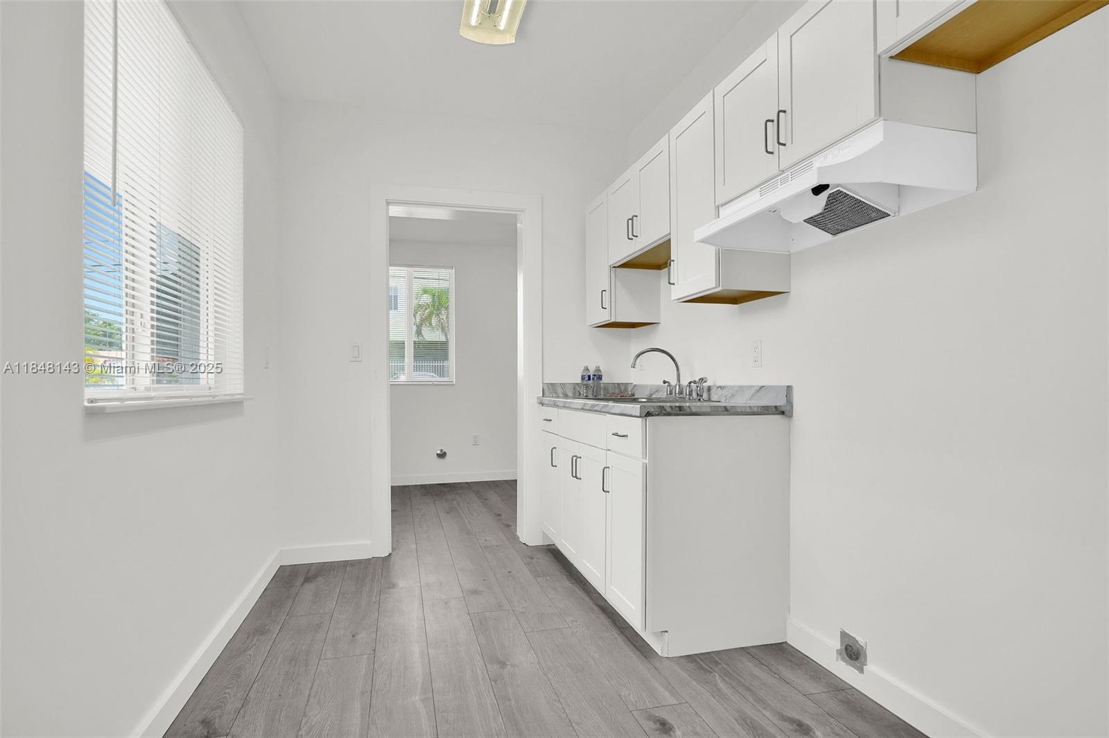 600 Northwest 25th Court Miami, FL 33125 - Photo 9 of 16 a kitchen with granite countertop white cabinets and white appliances