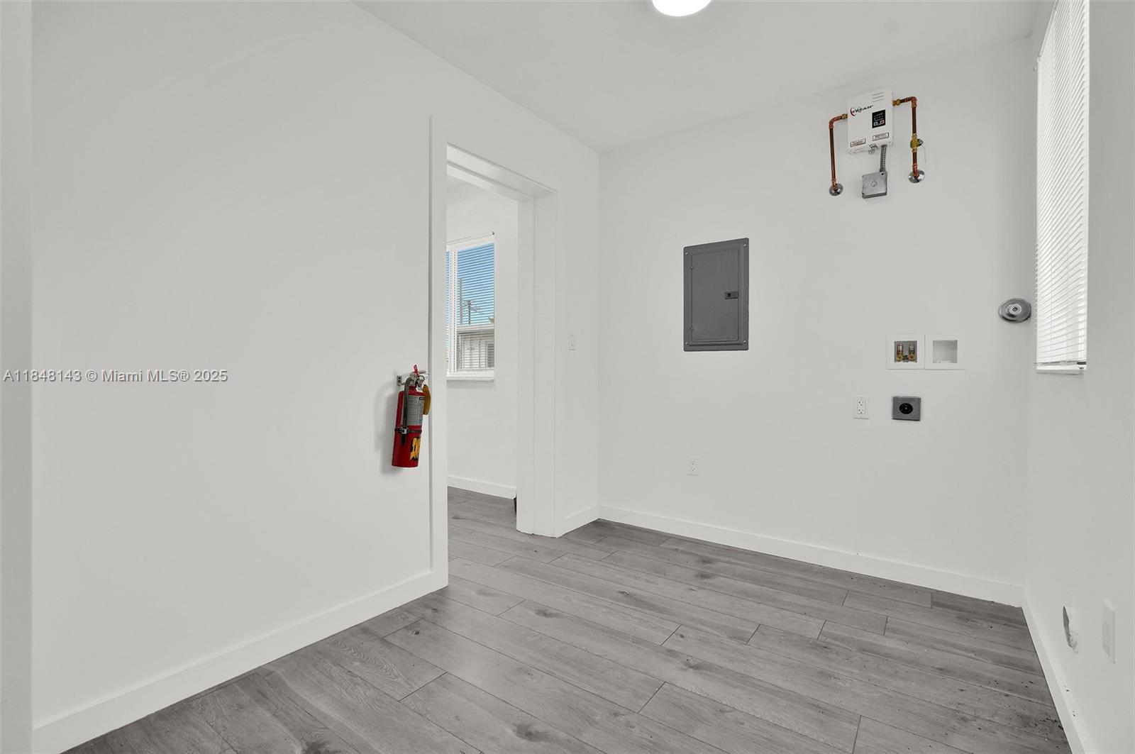 600 Northwest 25th Court Miami, FL 33125 - Photo 10 of 16 an empty room with wooden floor and windows