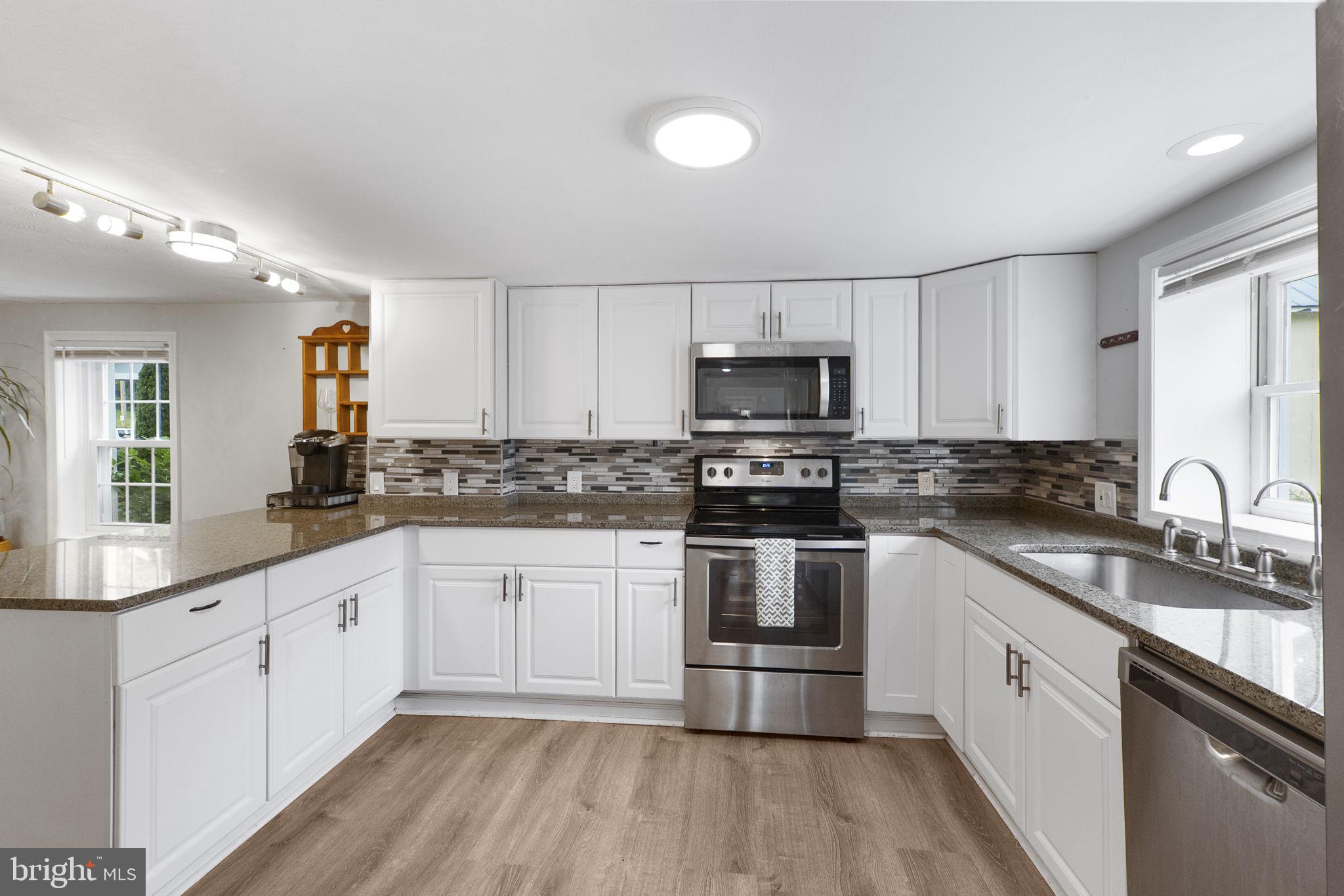 26001 Frederick Road Clarksburg, MD 20871 - Photo 7 of 46 a kitchen with sink a microwave and cabinets