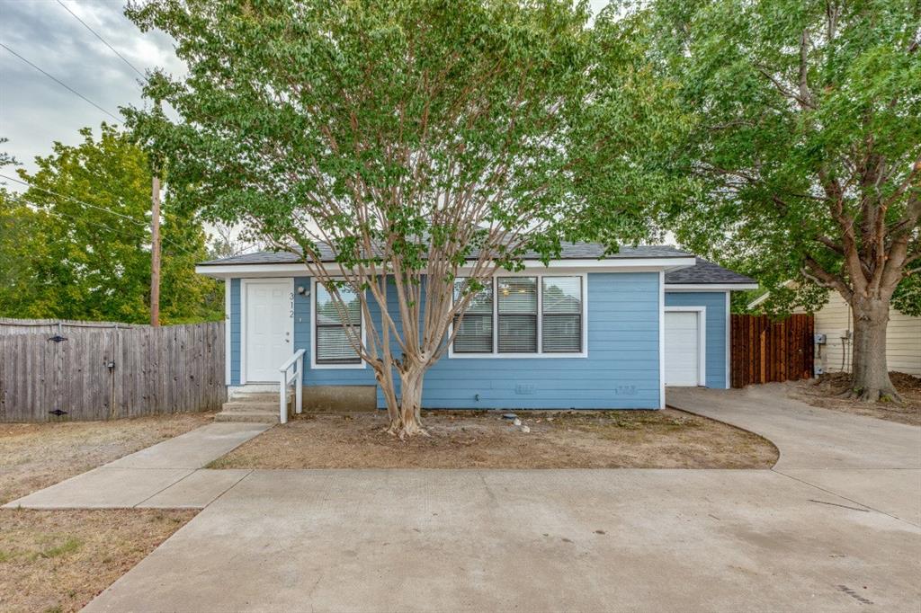 Front of structure with large driveway and parking area.