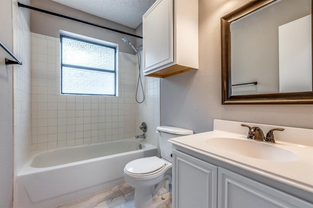 312 Mockingbird Lane Denton, TX 76209 - Photo 16 of 25 Bathroom with wood like flooring and ceramic tile shower and tub.
