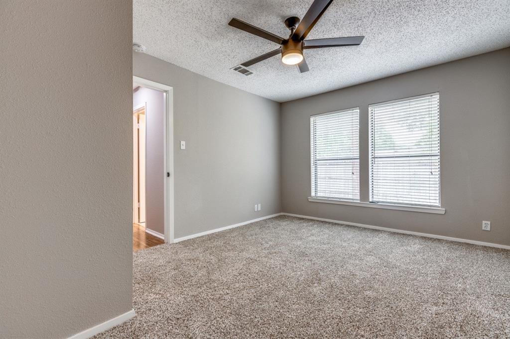 312 Mockingbird Lane Denton, TX 76209 - Photo 17 of 25 Bedroom with carpet, ceiling fan and large windows allowing for plenty of natural light.