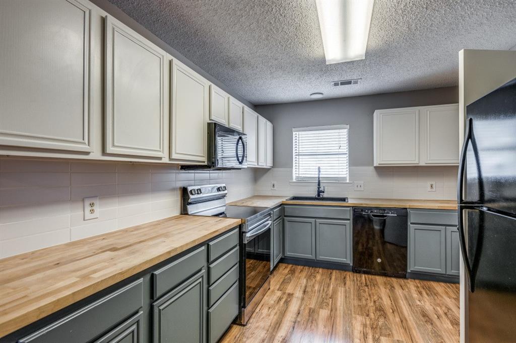 312 Mockingbird Lane Denton, TX 76209 - Photo 2 of 25 Kitchen with wood flooring and plenty of counter space.