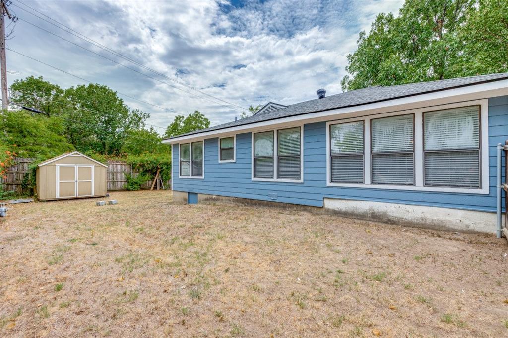 312 Mockingbird Lane Denton, TX 76209 - Photo 24 of 25 Back of home with a huge fenced in yard and outbuilding.