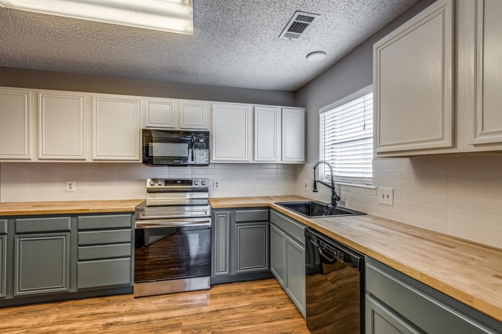 312 Mockingbird Lane Denton, TX 76209 - Photo 3 of 25 Kitchen with wood flooring and plenty of counter space.