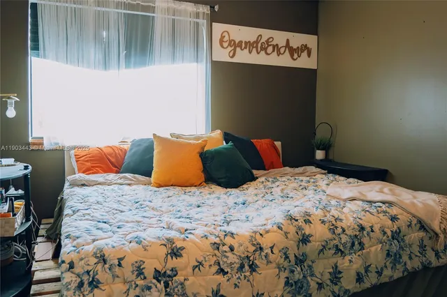 a bed sitting in a bedroom next to a cabinet
