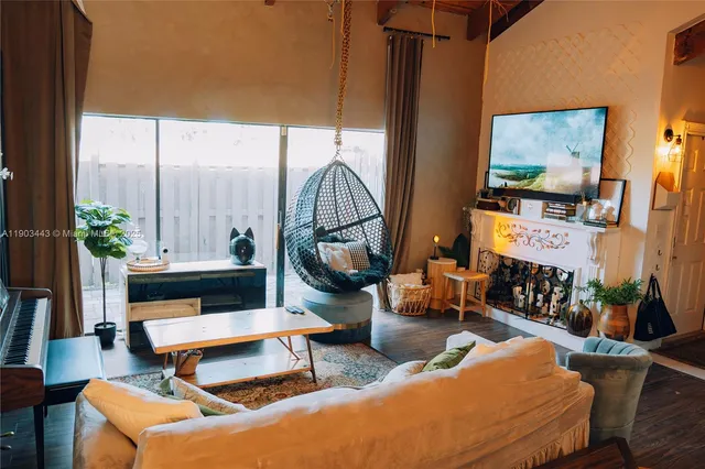 a living room with furniture a rug and a floor to ceiling window