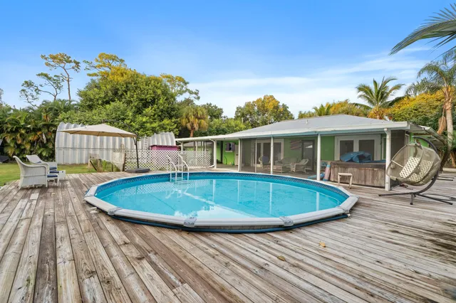 a house with wooden floor outdoor seating and yard in the back