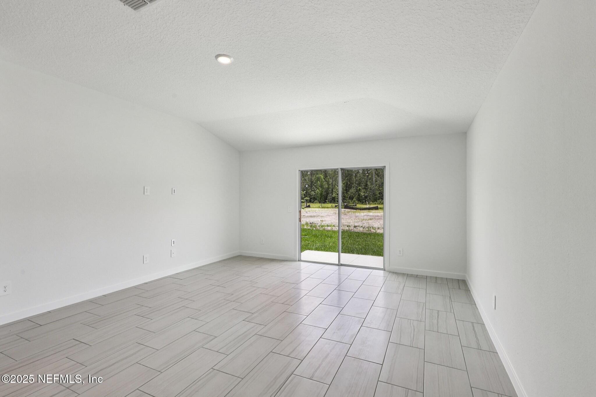9709 Amber Vlg Road Jacksonville, FL 32219 - Photo 22 of 25 an empty room with floor to ceiling window and an outdoor view