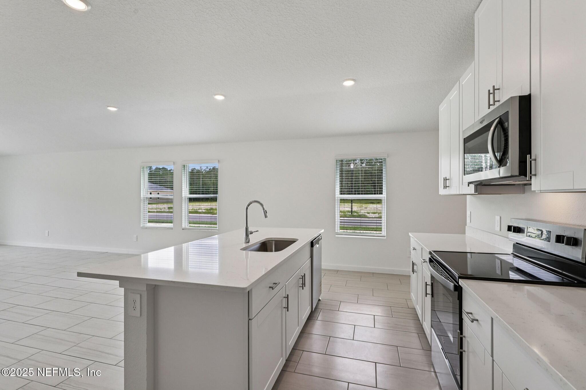 9709 Amber Vlg Road Jacksonville, FL 32219 - Photo 4 of 25 a kitchen with stainless steel appliances a sink stove and cabinets