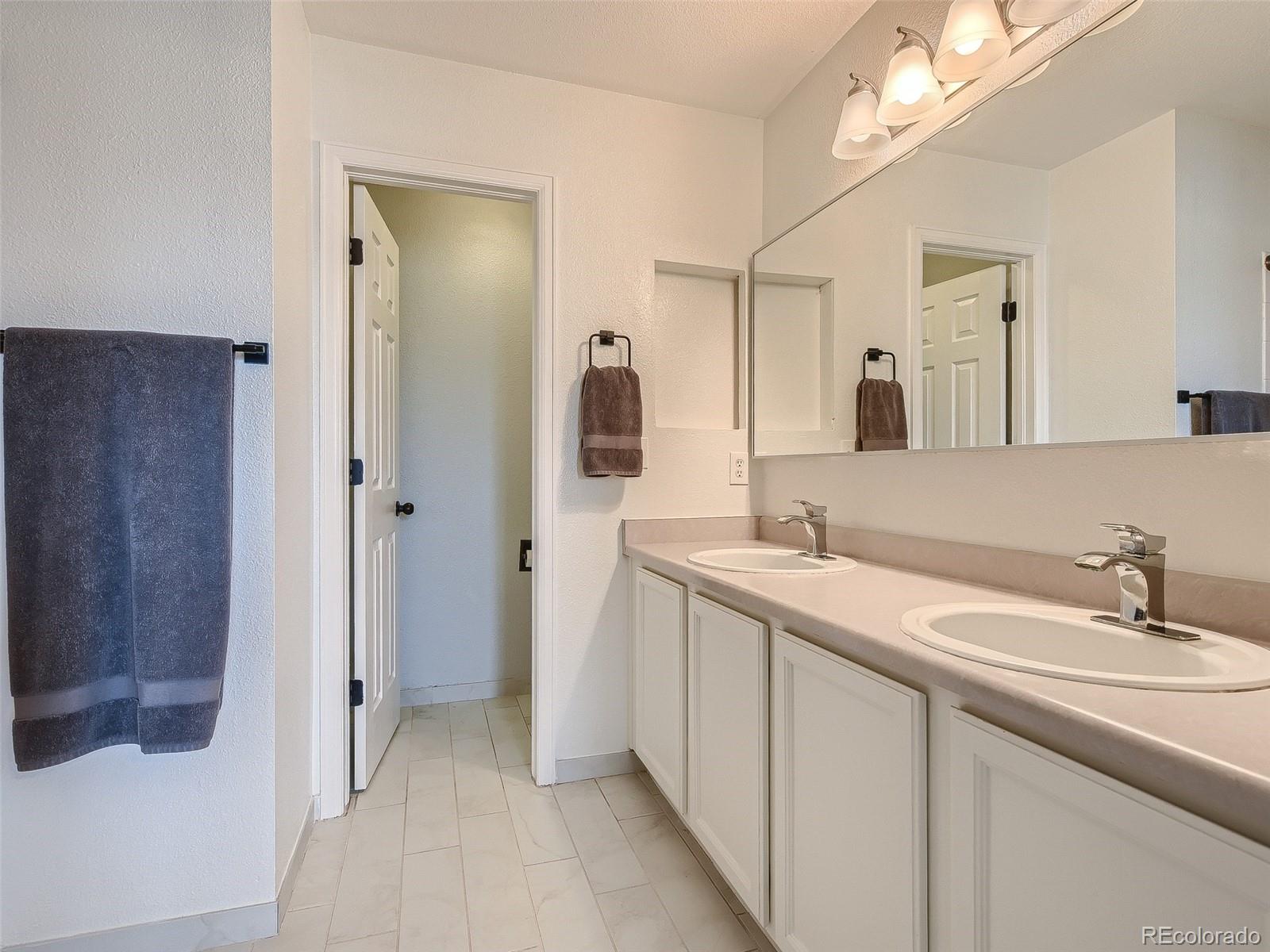 9760 South Castle Ridge Circle Highlands Ranch, CO 80129 - Photo 12 of 25 a bathroom with a sink a mirror and a shower