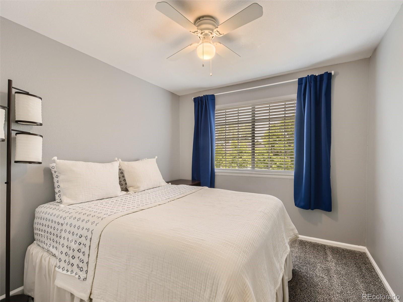 9760 South Castle Ridge Circle Highlands Ranch, CO 80129 - Photo 15 of 25 a bedroom with a large bed and two large window
