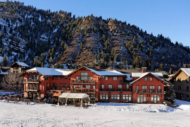 a front view of a building with large trees