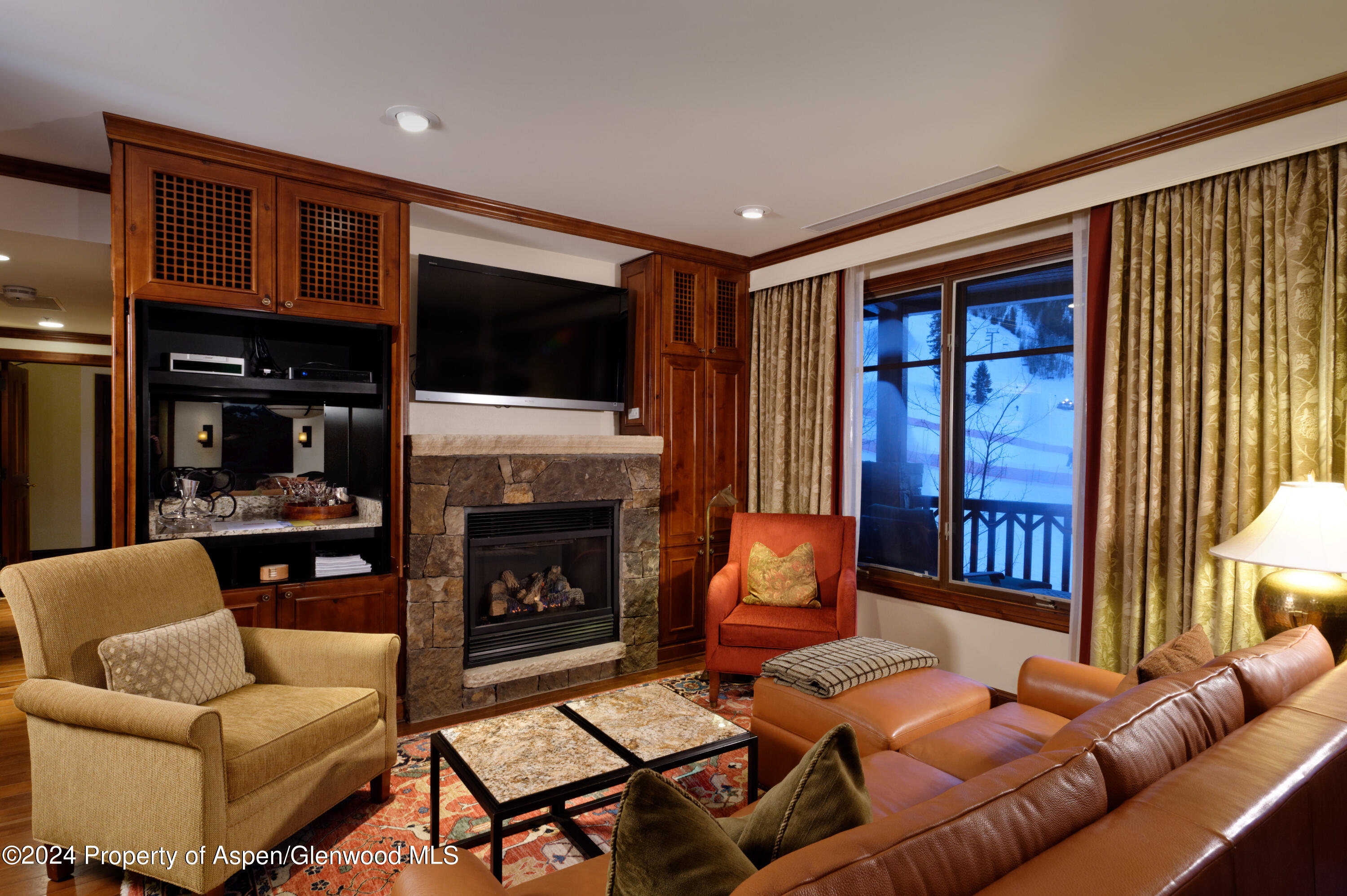 197 Prospector Road, Unit 24121 Aspen, CO 81611 - Photo 5 of 22 a living room with furniture a flat screen tv and a fireplace