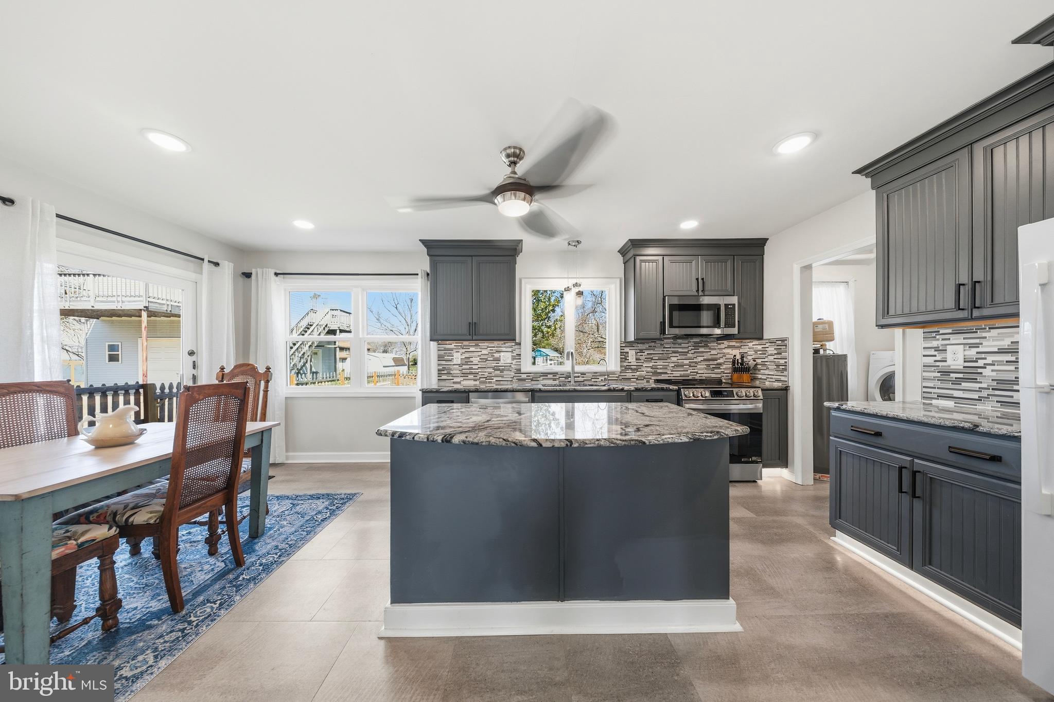 20826 Bivalve Wharf Road Bivalve, MD 21865 - Photo 16 of 52 a kitchen with stainless steel appliances granite countertop a stove top oven a sink dishwasher a dining table and chairs