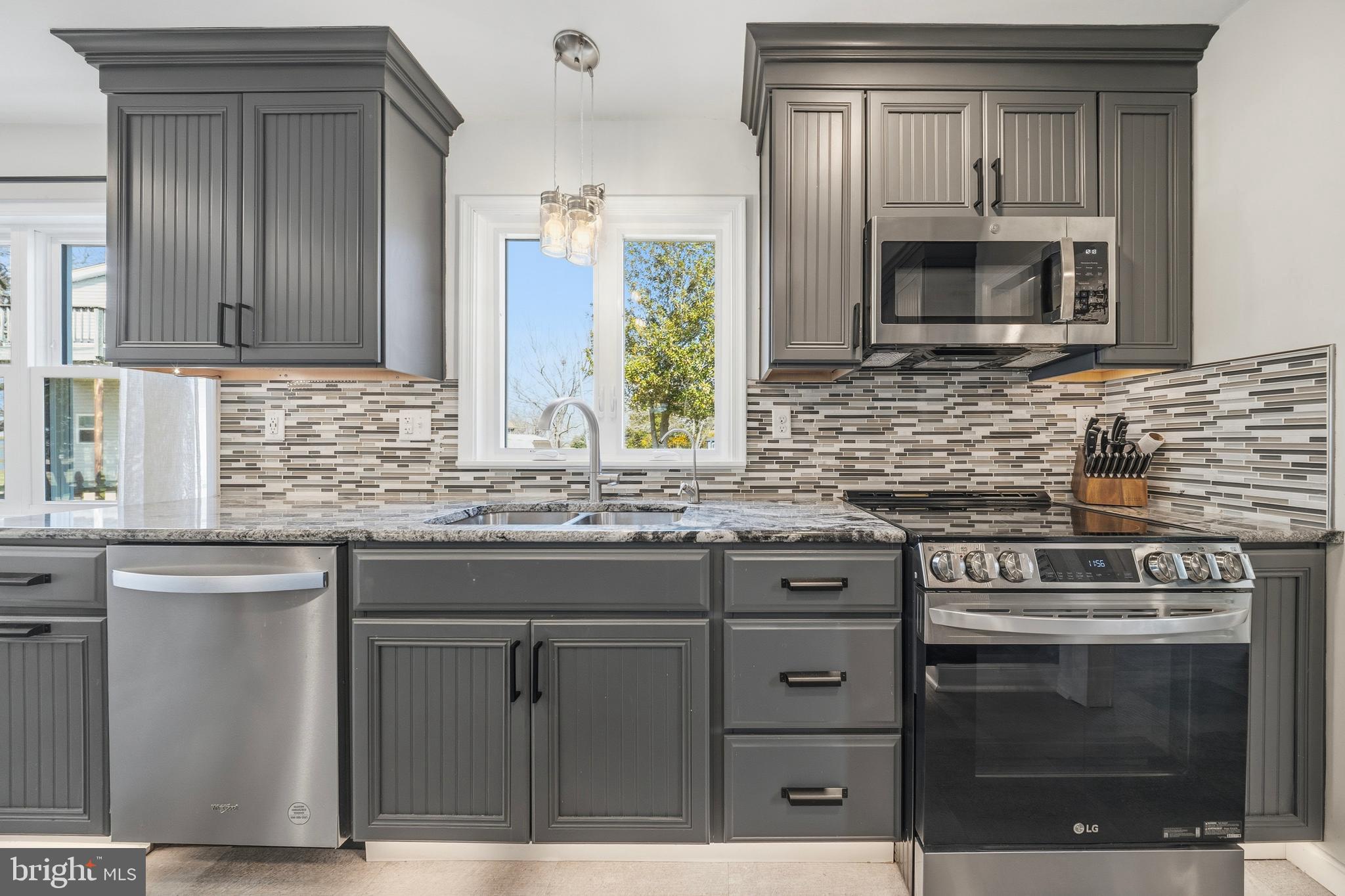 20826 Bivalve Wharf Road Bivalve, MD 21865 - Photo 18 of 52 a kitchen with granite countertop a stove microwave and sink
