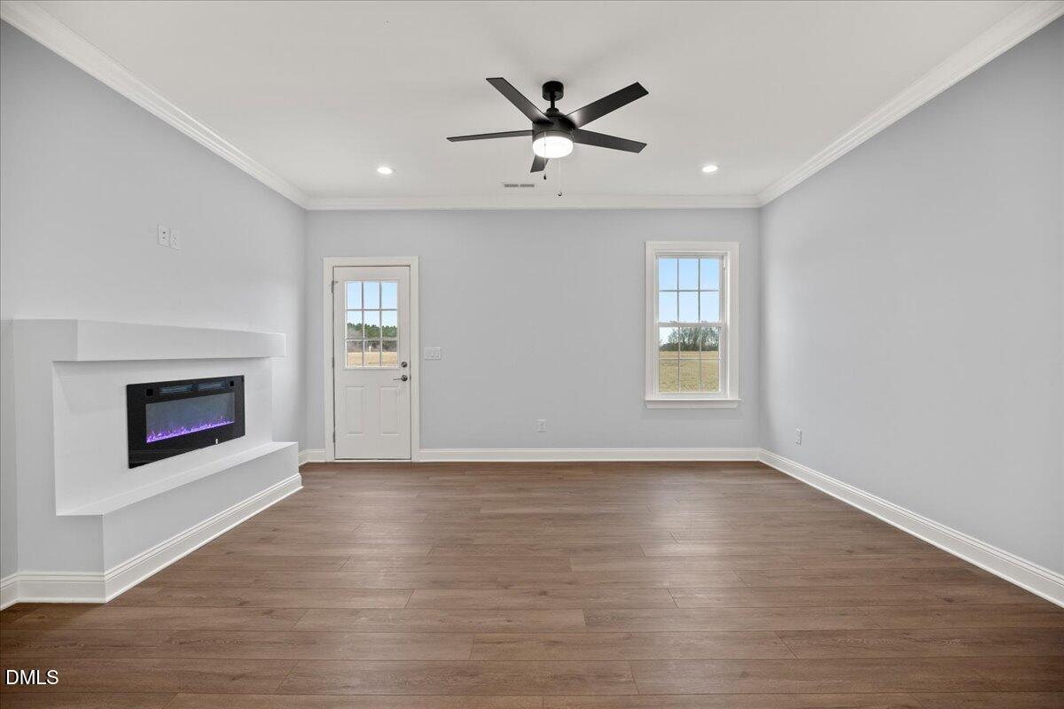 1300 Nick Coley Road Whitakers, NC 27891 - Photo 22 of 47 an empty room with wooden floor a ceiling fan and windows
