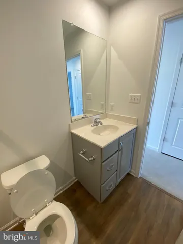 a bathroom with a sink vanity mirror and toilet