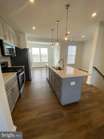a living room with hard wood floors and a kitchen view
