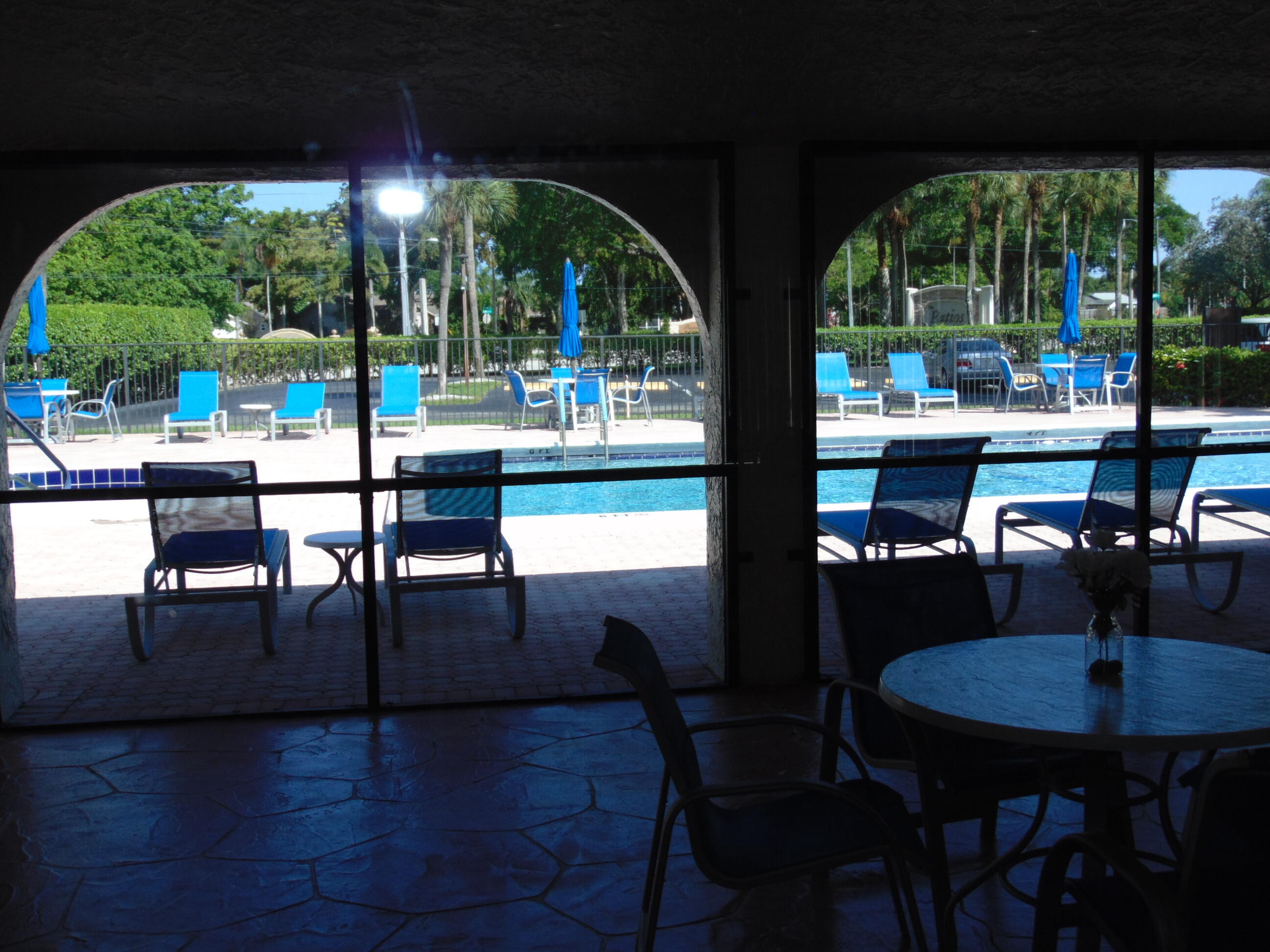 9220 Southwest 14th Street, Unit 3103 Boca Raton, FL 33428 - Photo 46 of 58 a view of a patio with a table chairs and a floor to ceiling window
