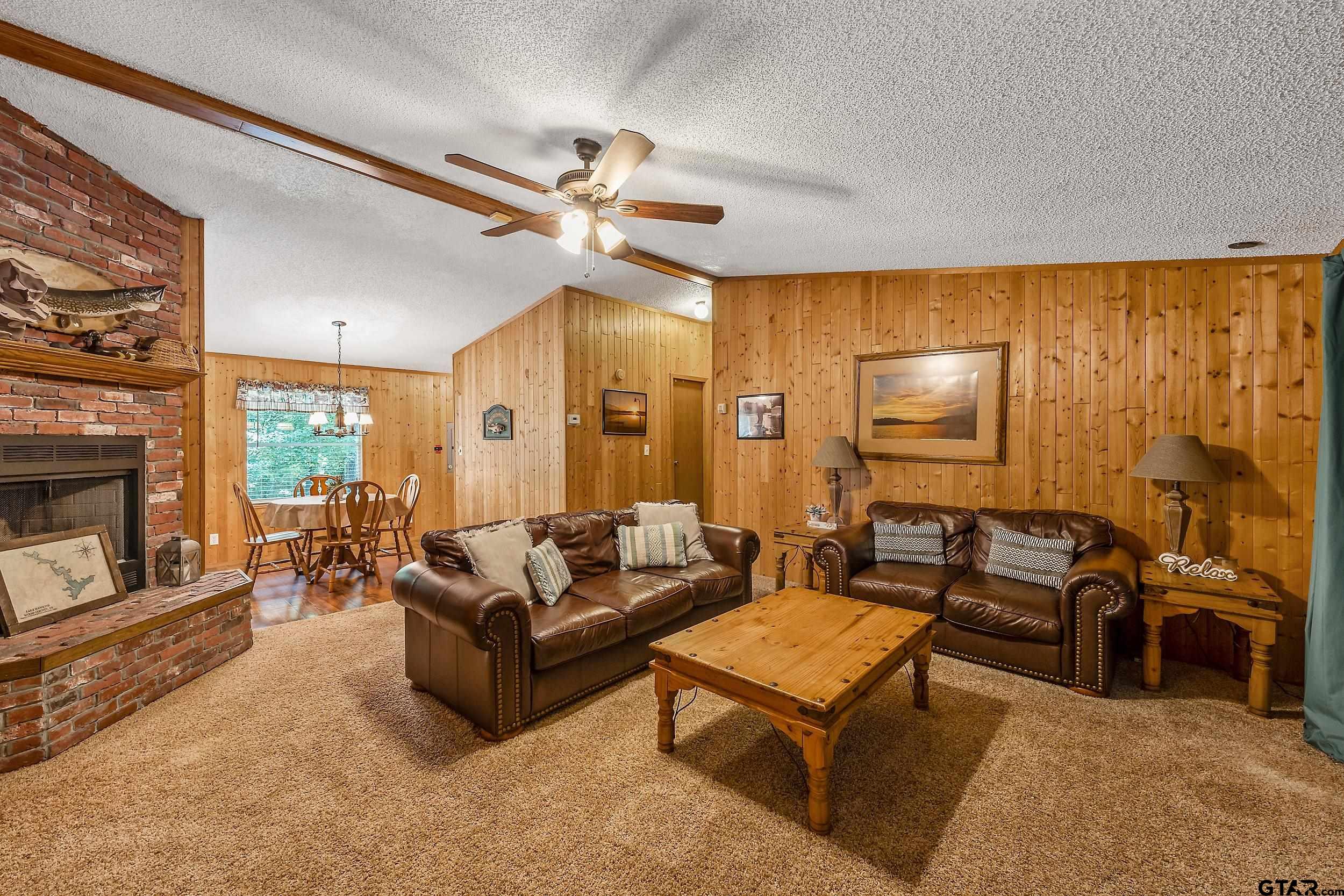749 County Road 3420 Hawkins, TX 75765 - Photo 6 of 29 a living room with furniture a fireplace and a flat screen tv