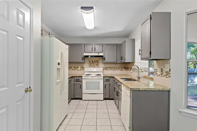 a kitchen with a sink stove and refrigerator