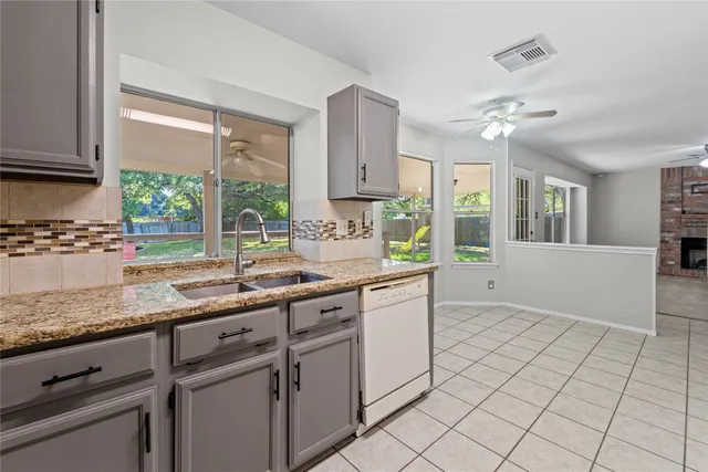 a kitchen with a sink window and cabinets