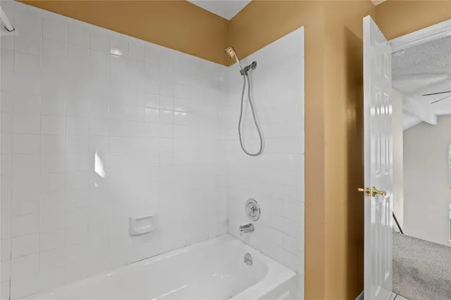 a bathroom with a bath tub with a shower