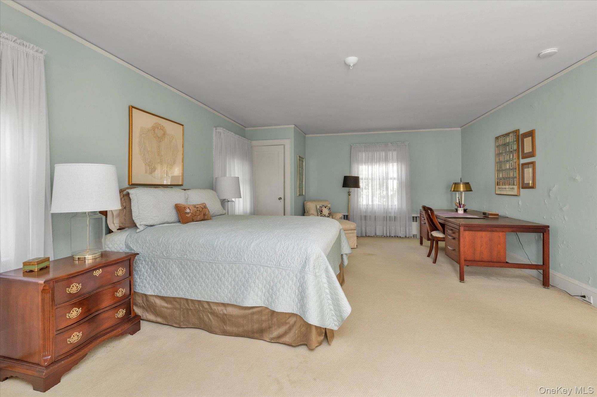 57 Beacon Hill Road Port Washington, NY 11050 - Photo 18 of 25 a spacious bedroom with a bed and a table