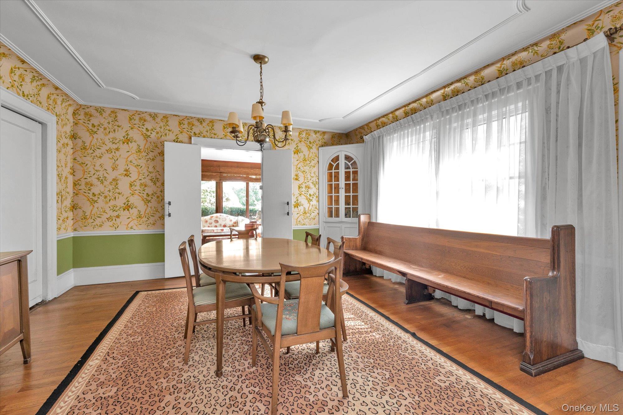 57 Beacon Hill Road Port Washington, NY 11050 - Photo 7 of 25 a living room with a table chairs and a dining table