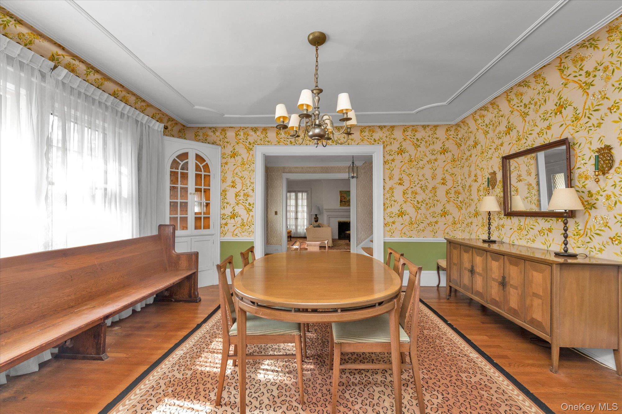 57 Beacon Hill Road Port Washington, NY 11050 - Photo 8 of 25 a dining room with chandelier and wooden floor