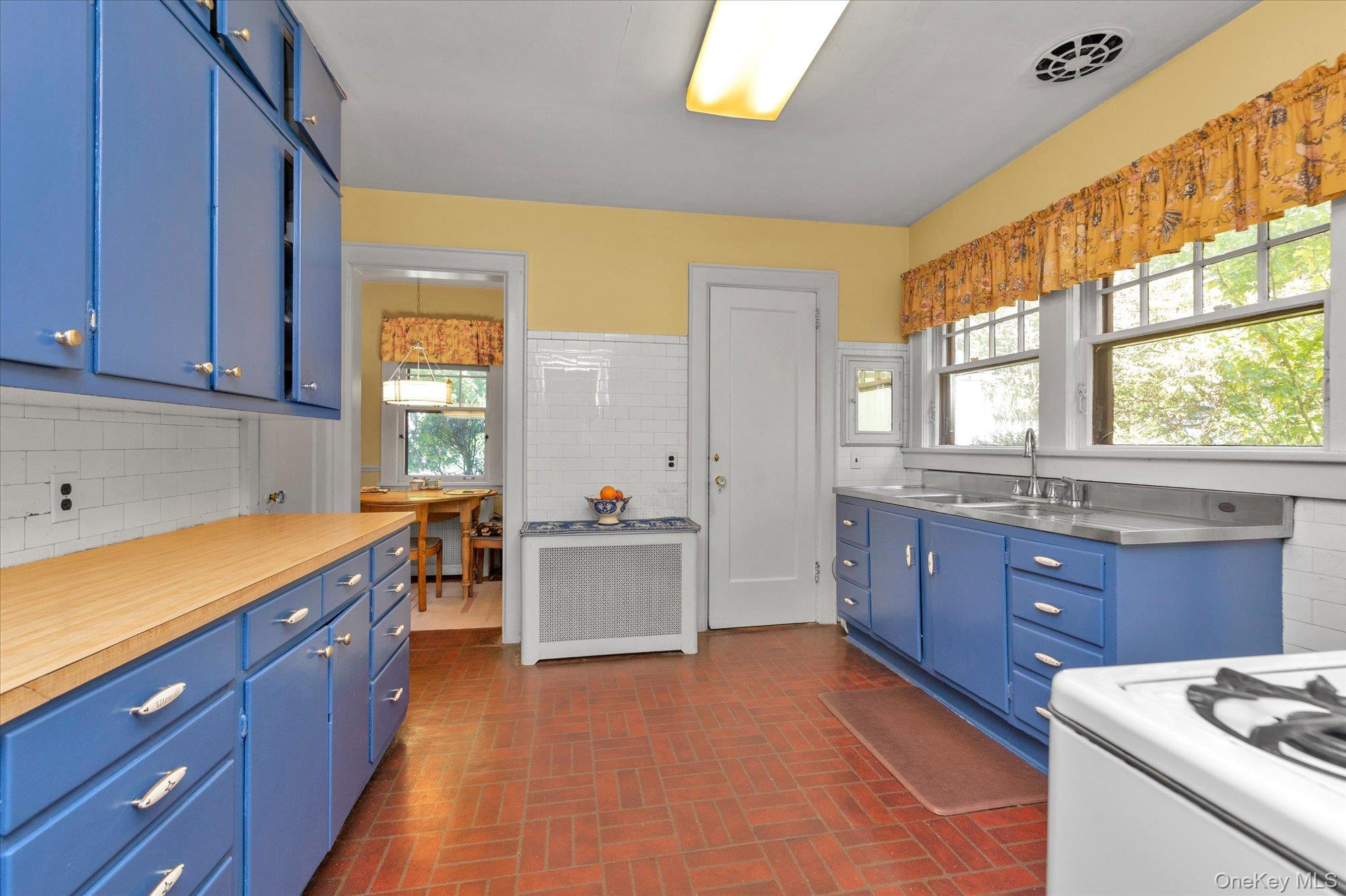 57 Beacon Hill Road Port Washington, NY 11050 - Photo 10 of 25 a kitchen with stainless steel appliances sink cabinets and wooden floor